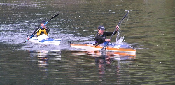Two kayakers navigating their way up stream